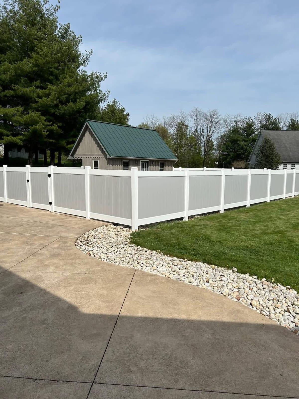 Grey vinyl privacy fence along a driveway